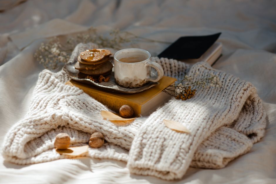 Warm knitted sweater with coffee and cookies, perfect for a cozy morning.